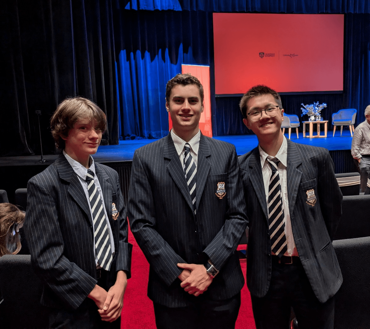 A group of boys in suits standing in front of a stage

AI-generated content may be incorrect.