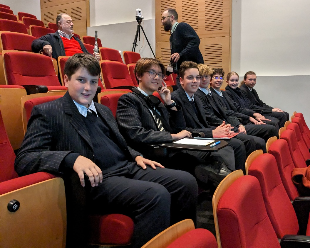 A group of people sitting in a lecture hall

Description automatically generated