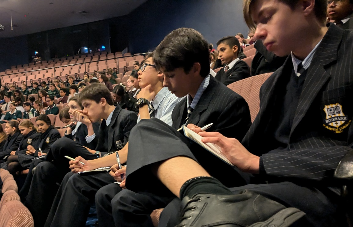 A group of people sitting in a auditorium

Description automatically generated